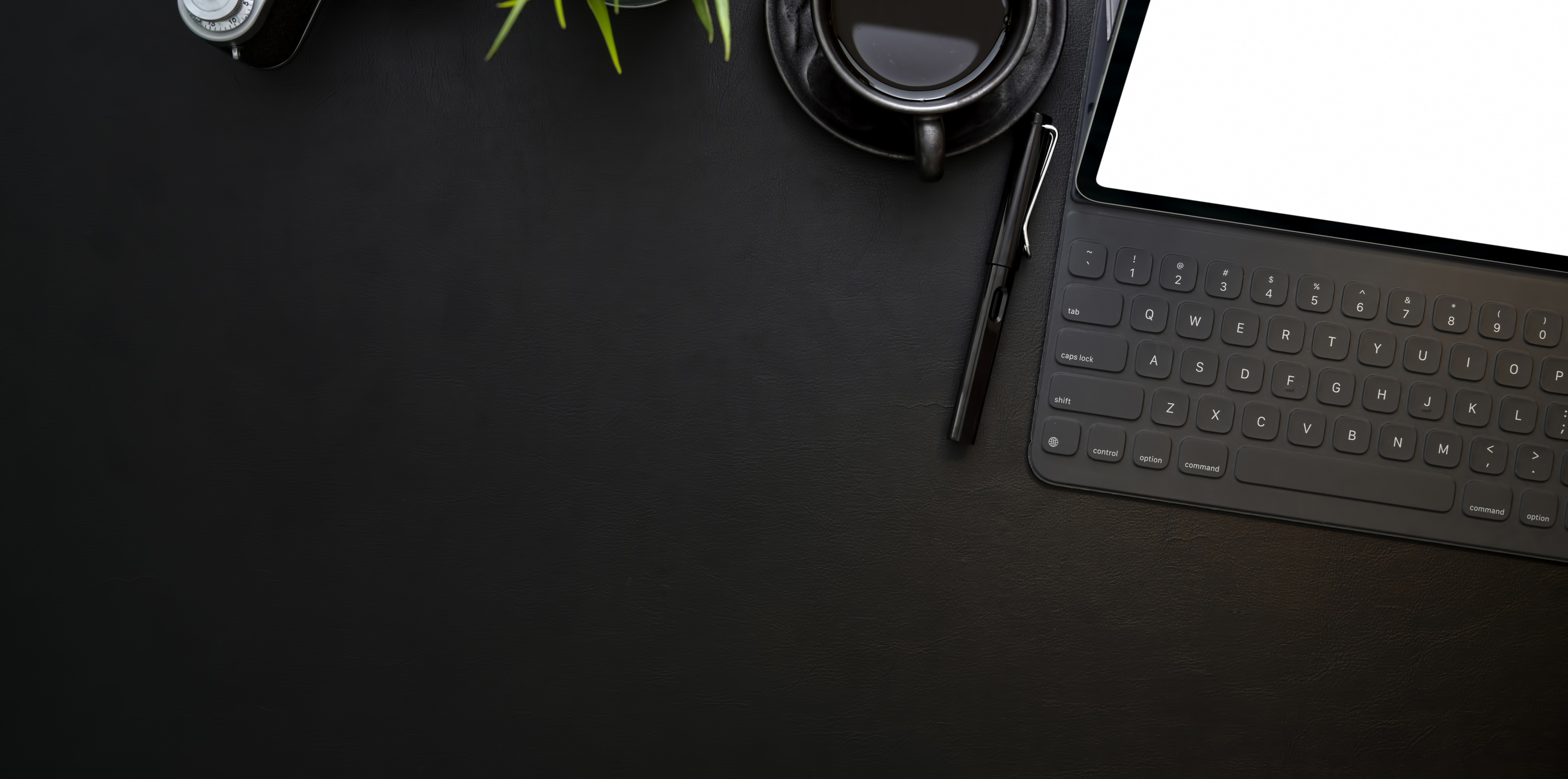 Digitizing tablet with empty screen and keyboard on black desk